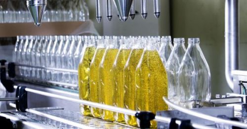 Процес розливу соняшникової олії у пляшки на виробництві
