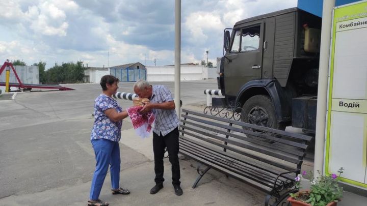 Завідуюча лабораторією Ніна Шастун вручає коровай водію першої машини із зерном Анатолію Куковиці